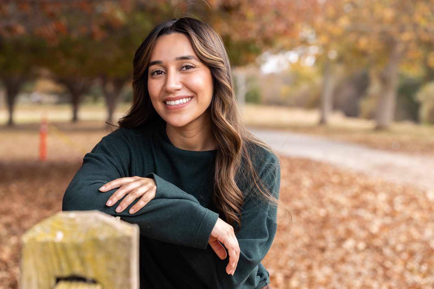 Paola Villa smiling outdoors among autumn foliage